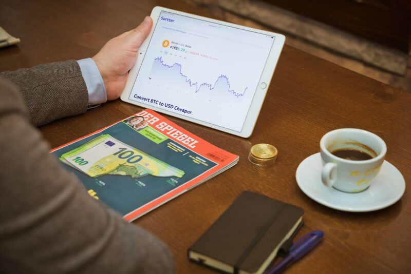 a person sitting at a table with a tablet and a cup of coffee